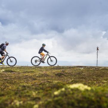 Two cyclists are cycling on mountains.