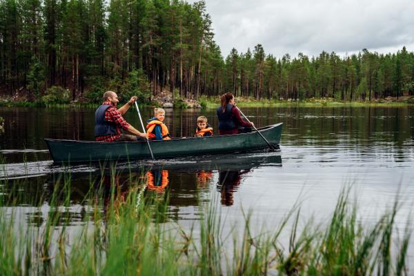 Familj och paddlar kanot.