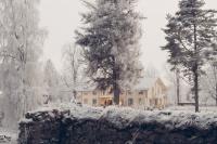 Herrgårdsbyggnad omgiven av vinterlandskap.