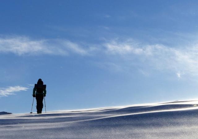 Person som vandrar med snöskor på fjäll.