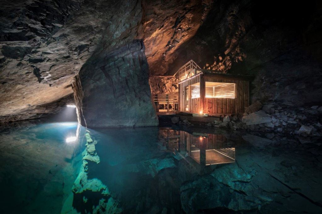 En upplyst bastu syns vid en underjordisk sjö i en gruva.