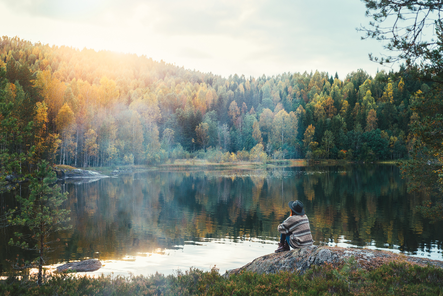 Rania Ronntoft sitter på en sten vid en sjö.