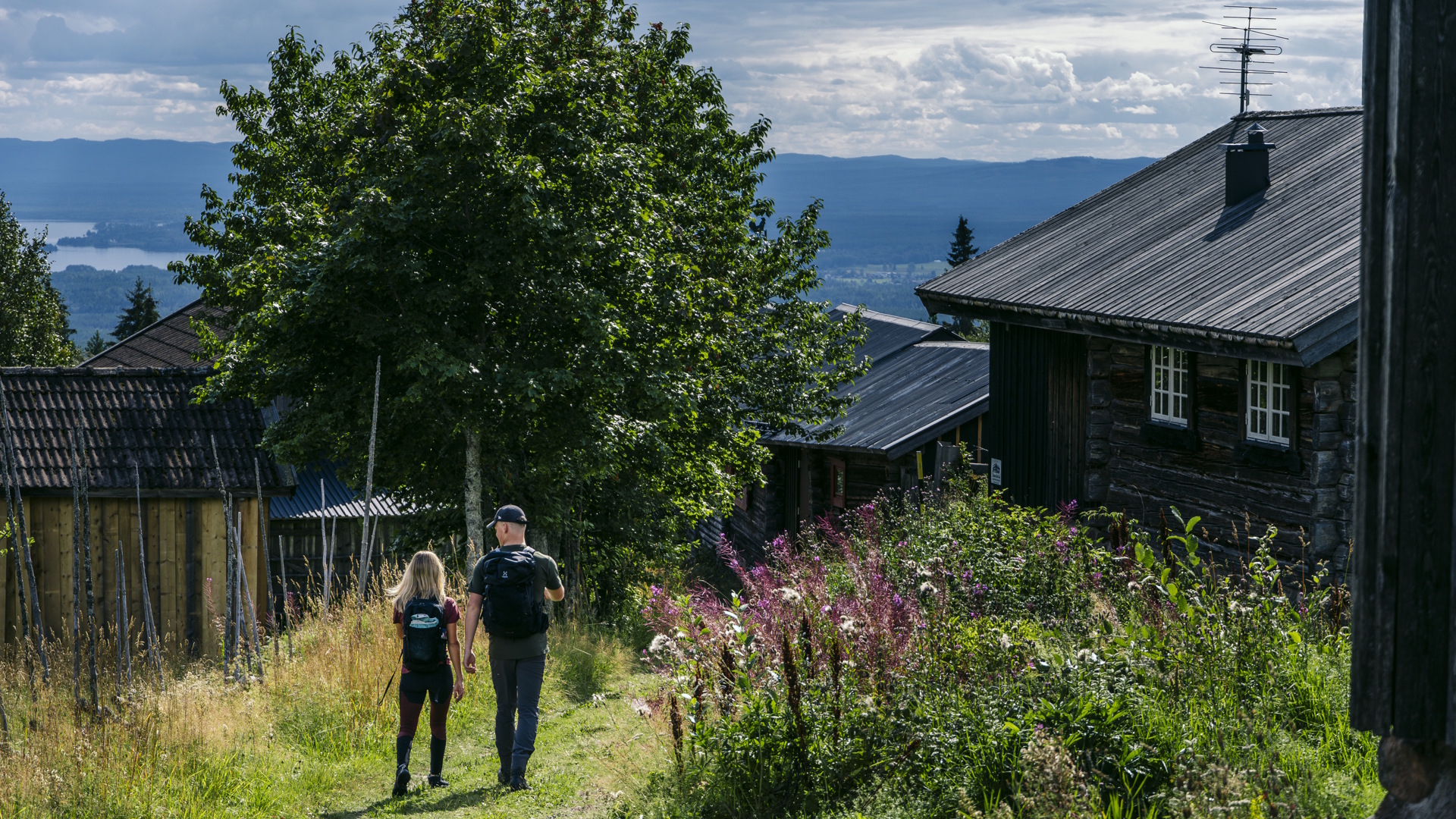 Ett par vandrar bland gråtimrade stugor i Fryksås.