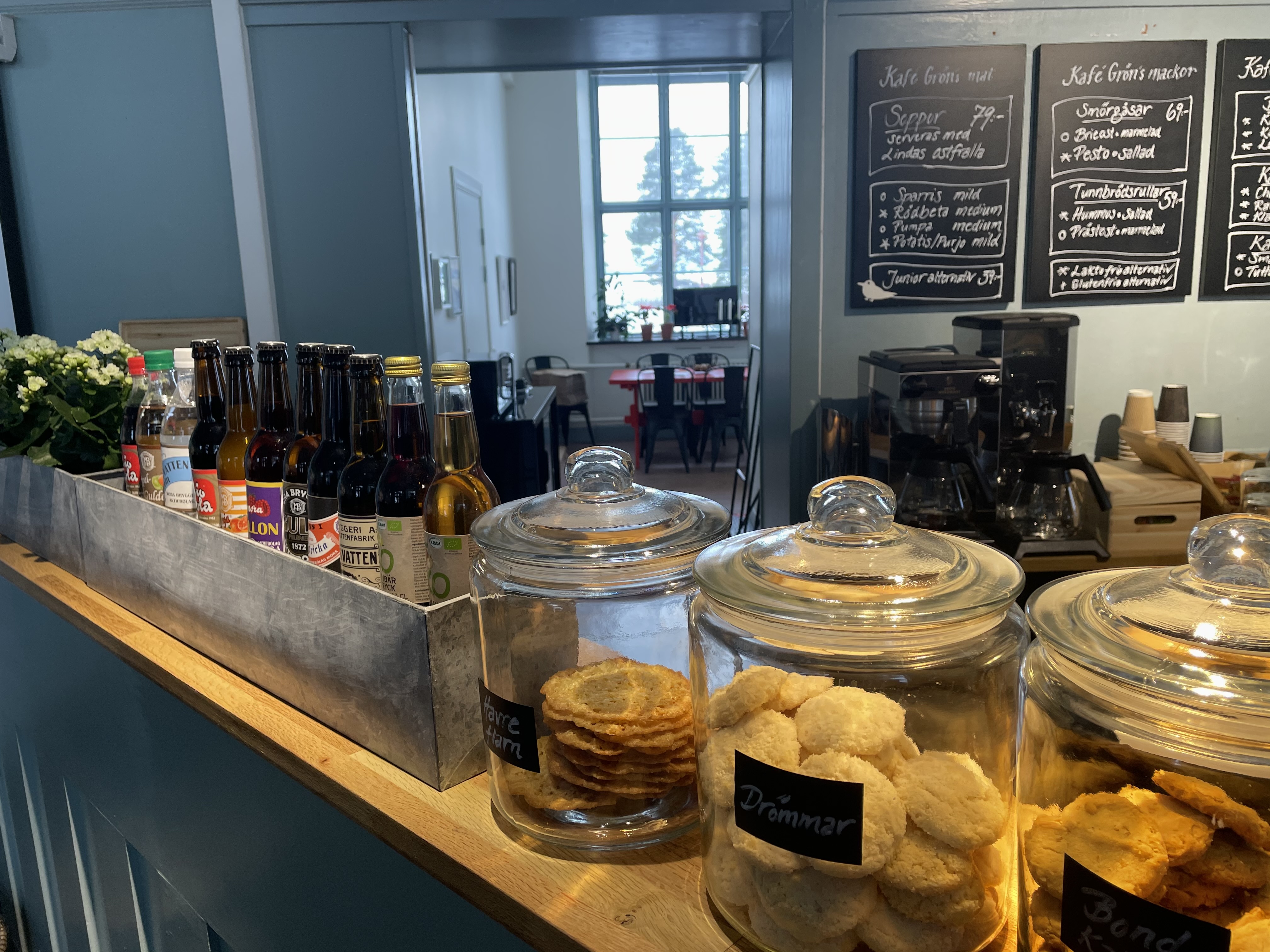 Detaljbild på cafédisk med glasburkar fyllda med småkakor och läskflaskor.