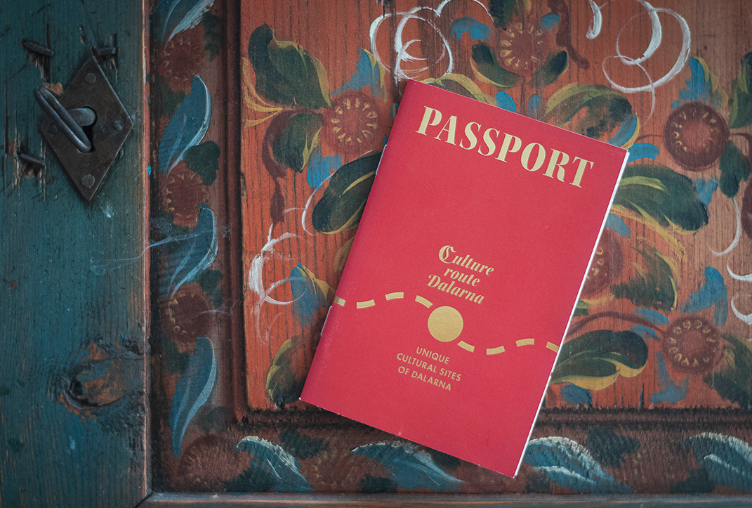 Ett rött pass syns ovanpå gammalt kurbitsmålat trä.