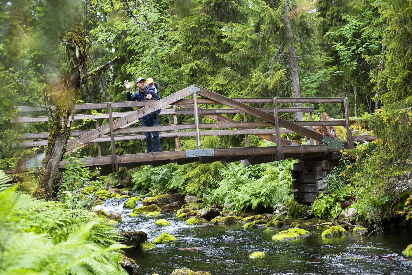 Far med dotter vandrar på en bro.