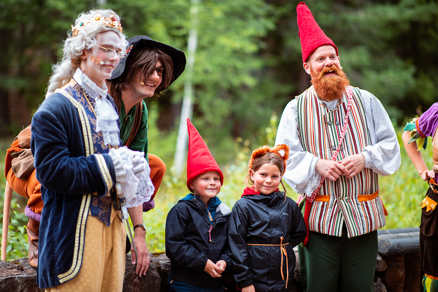 Två glada barn och utklädda vuxna på Tomteland.
