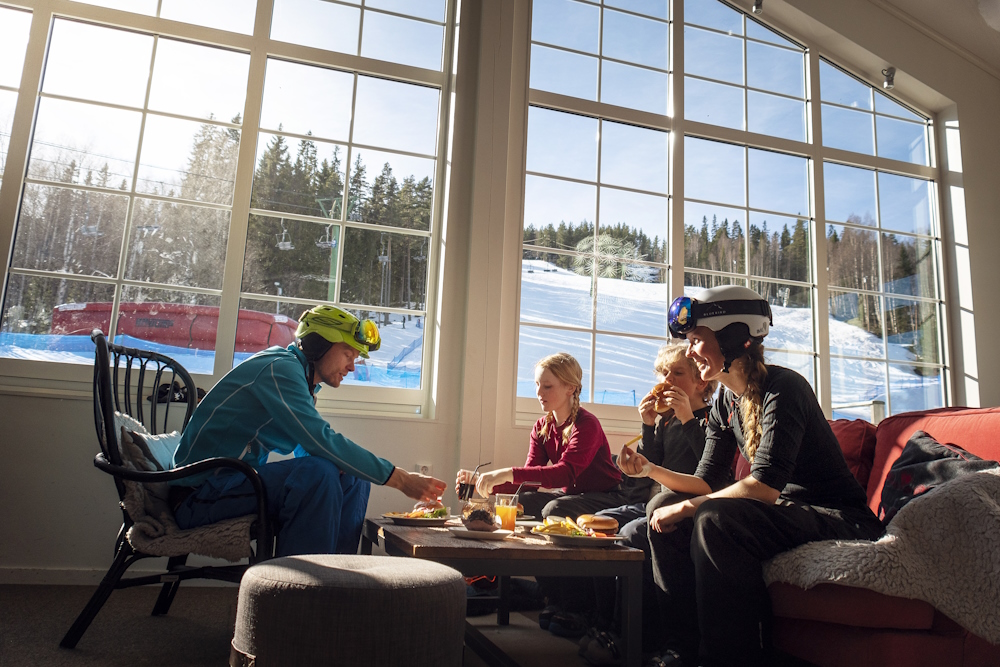 Familj äter lunch i restaurangen mitt i skidbacken.