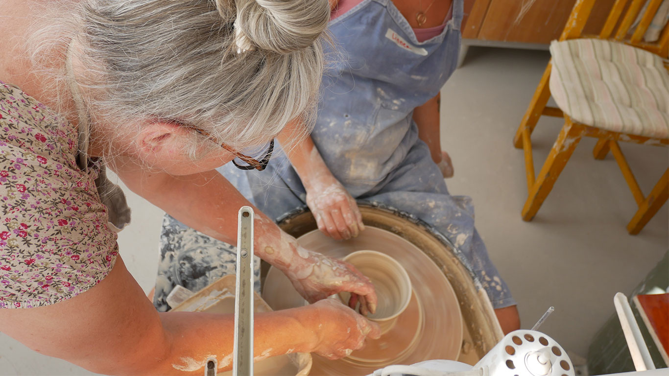 Ulrika Ström instruerar kursdeltagare vid drejskivan.