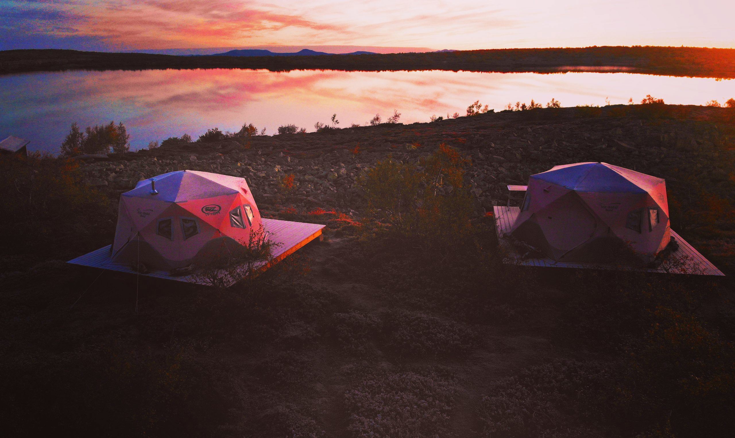 Tält vid stranden av en sjö.