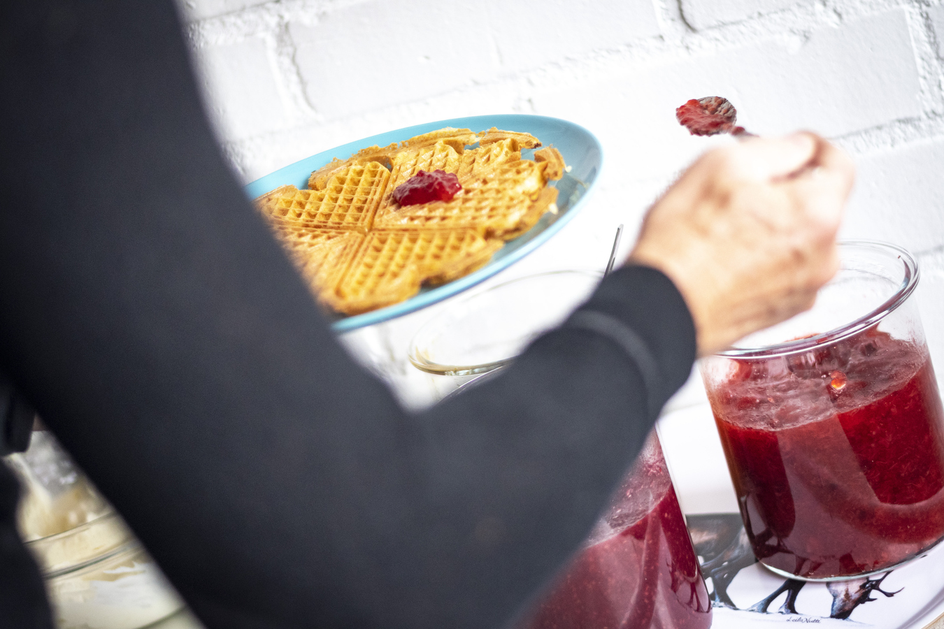 Skopar sylt på sin våffla i restaurangen.