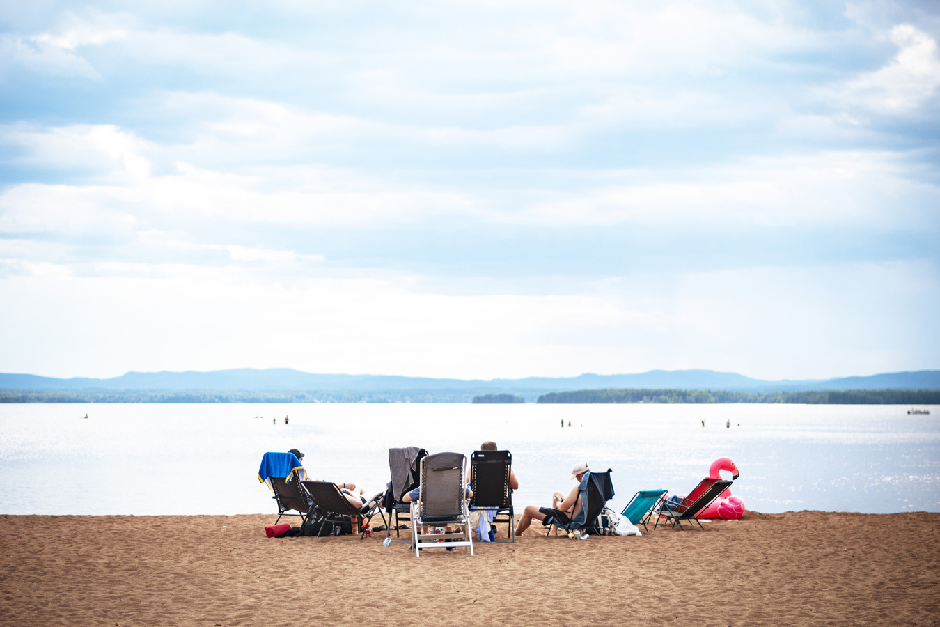 Solstolar på sandstranden vid Orsa Camping.