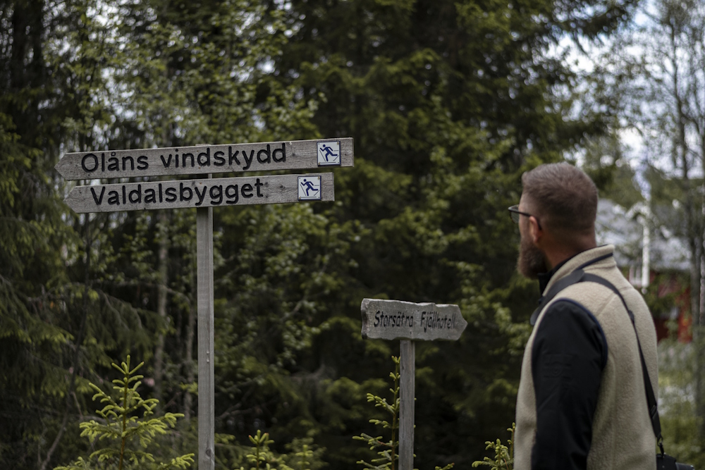 En man läser skyltar som visar vägen.