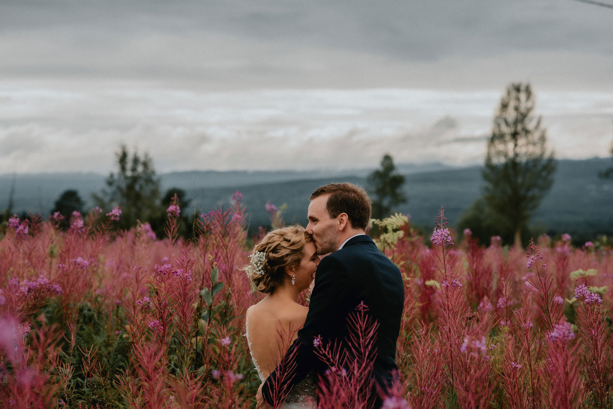 Brudpar i Dalarna fotograferade på en blomsteräng av bröllopsfotograf Marta Englund.