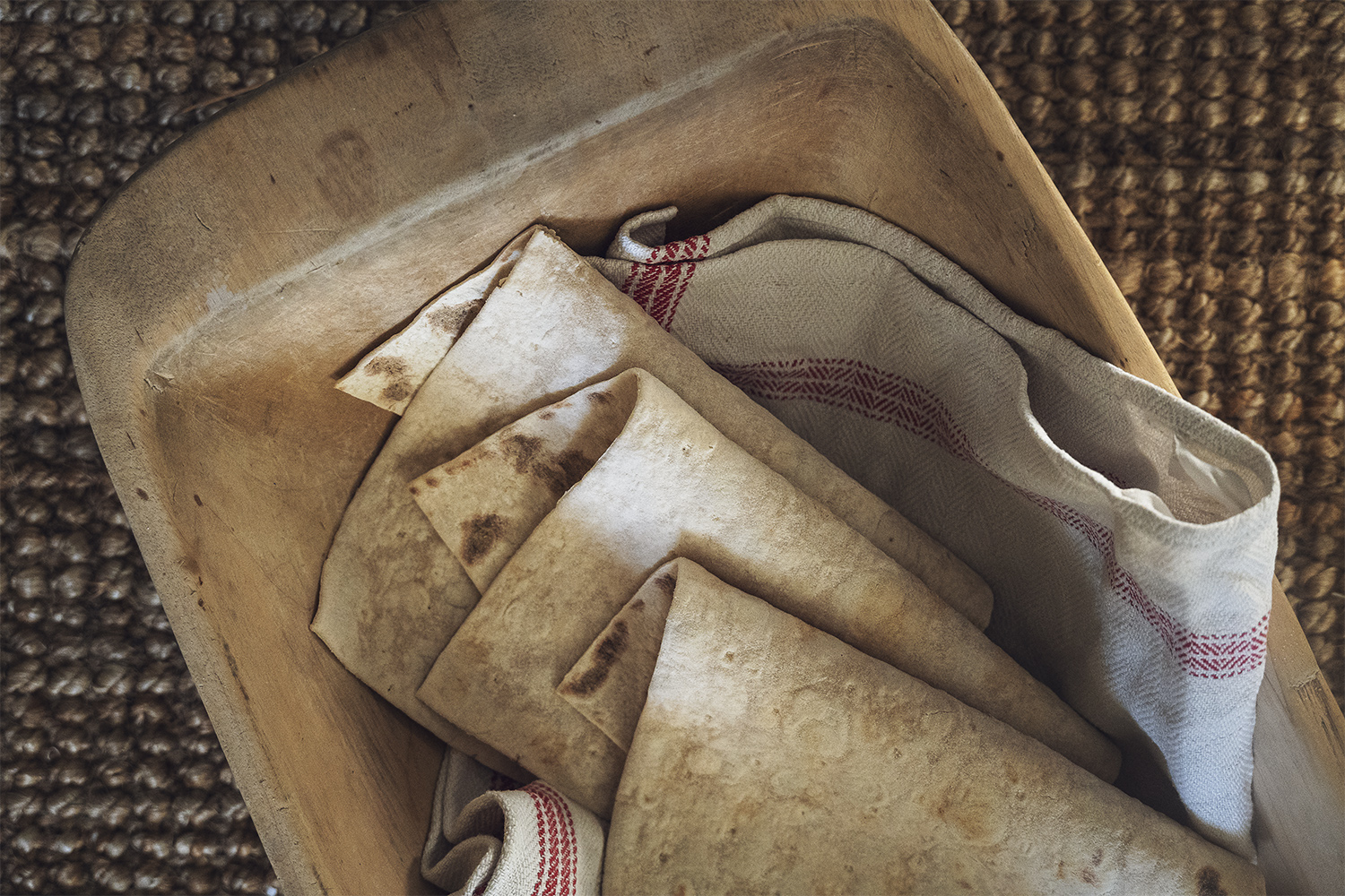 Ett träfat med mjukt tunnbröd i en handduk.