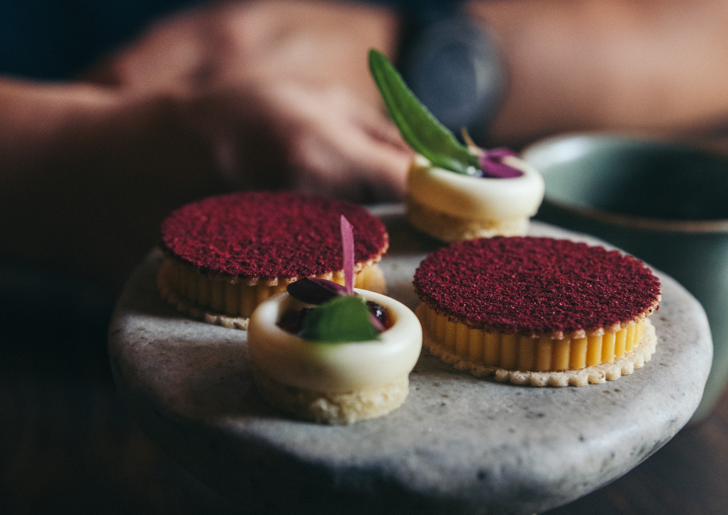 Vackra bakverk och desserter uppdukade på ett stenfat.