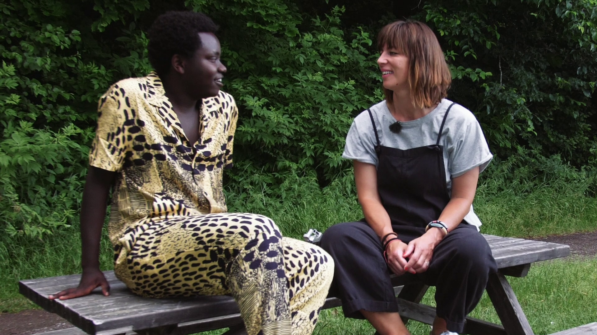 Idolvinnaren Tusse Chiza och Isabelle McAllister sitter på en träbänk.