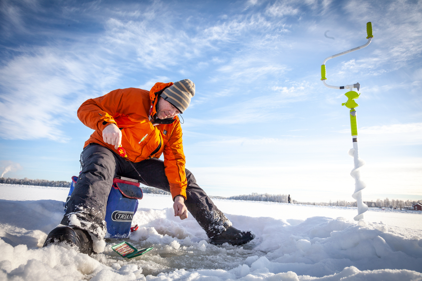 Isfiskare drar upp fisk.