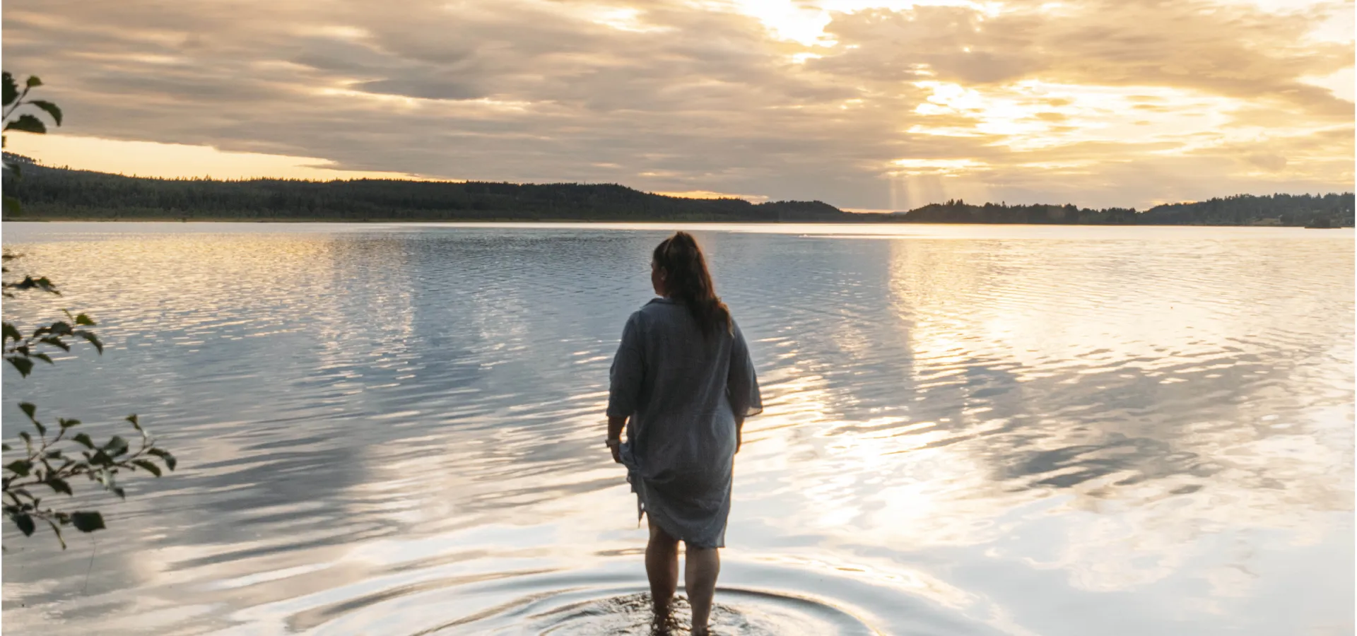 En kvinna tar sina första steg ut i vattnet för ett kvällsdopp.