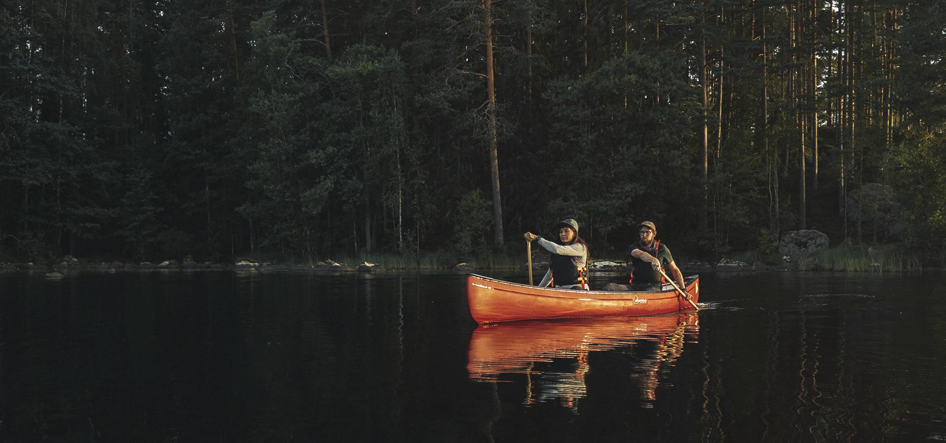 Två människor som paddlar kanot