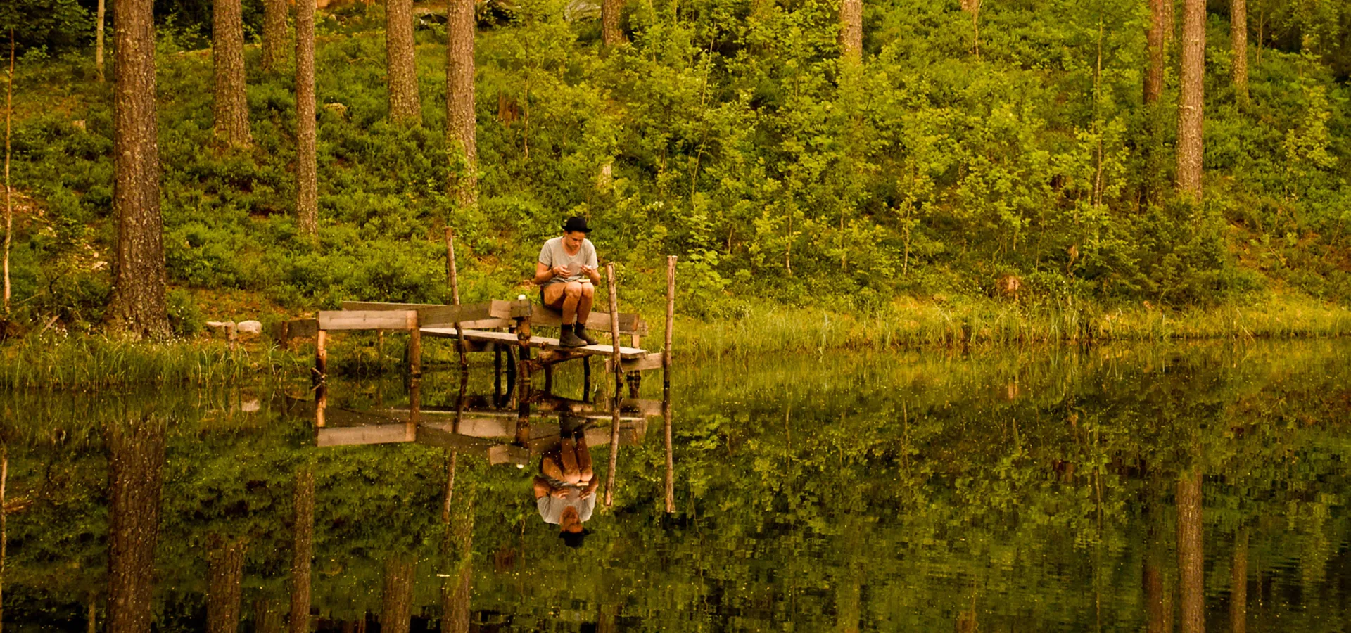 Man som sitter vid en brygga.