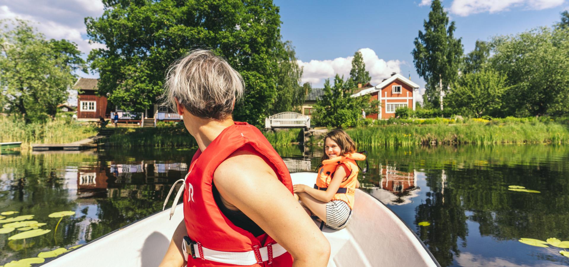 Mamma och dotter paddlar båt vid Carl Larsson-gården i Sundborn.