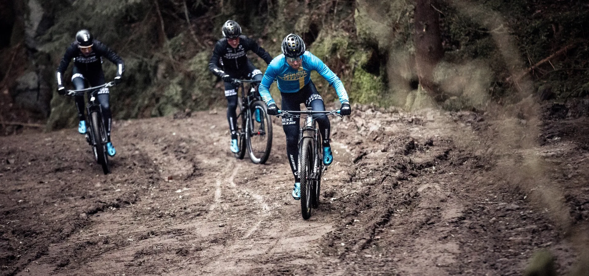 Cyklister på en lerig väg.