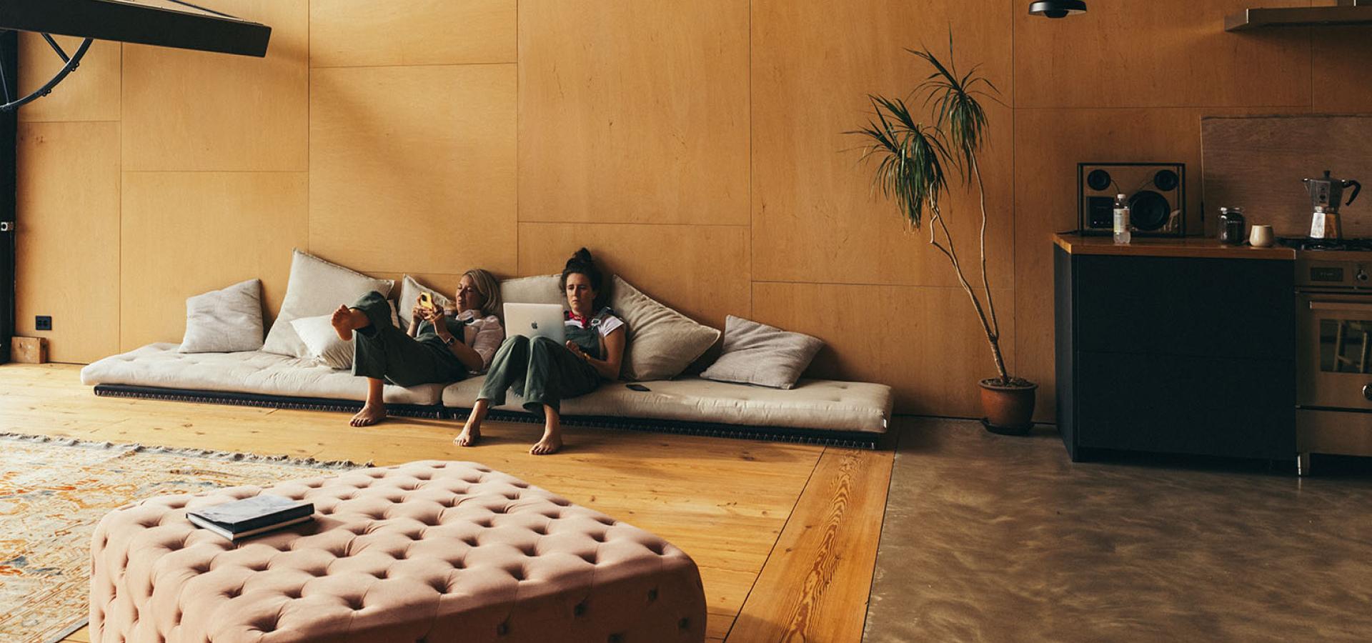 Två tjejer som jobbar i en soffa.