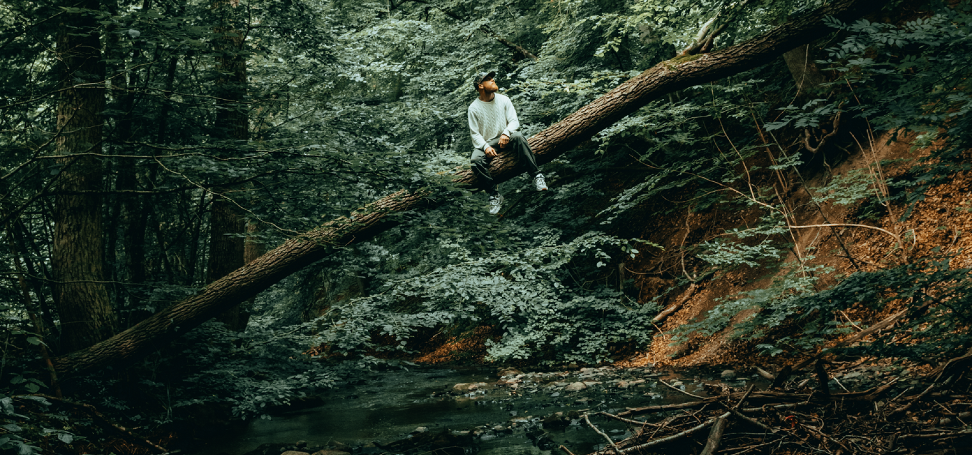 Självporträtt på Fotografen Jakob Ebbinger som sitter på en trädstam.
