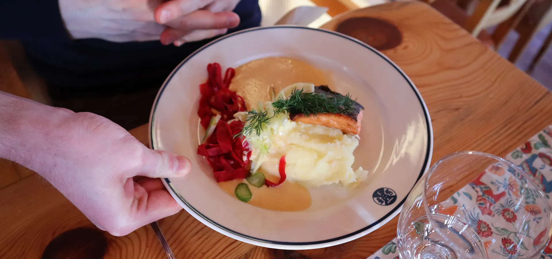 En tallrik med fisk och potatismos serveras vid bordet.