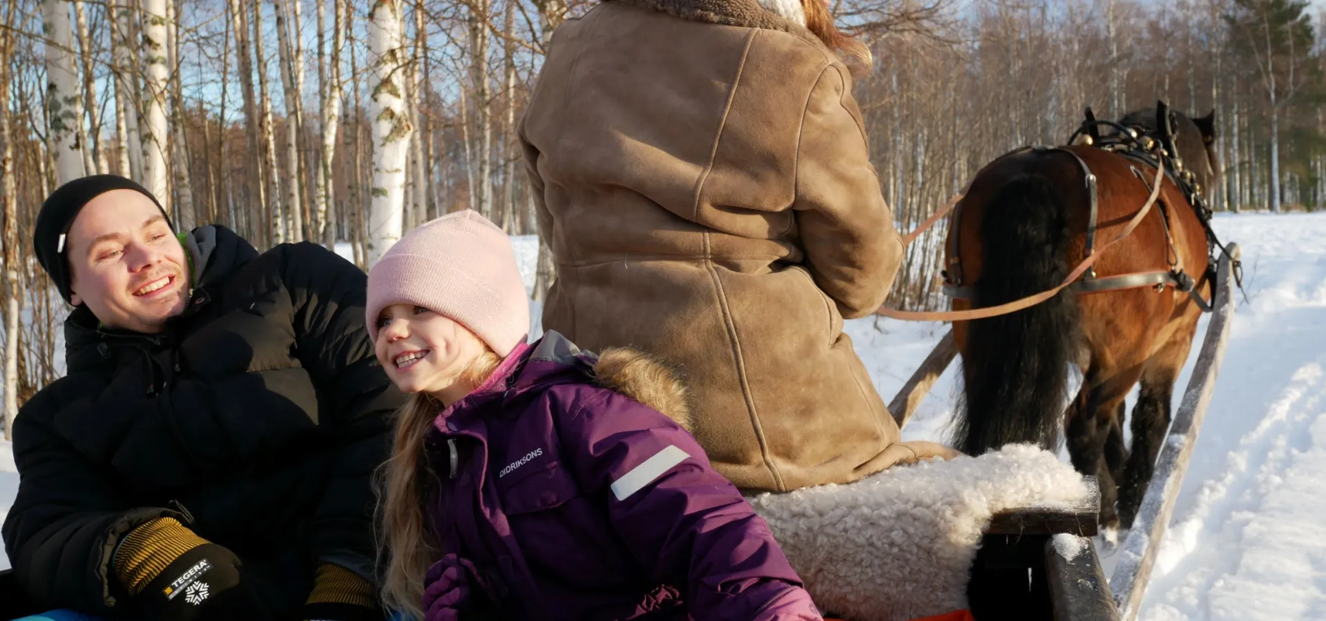 Familj åker häst och släde.