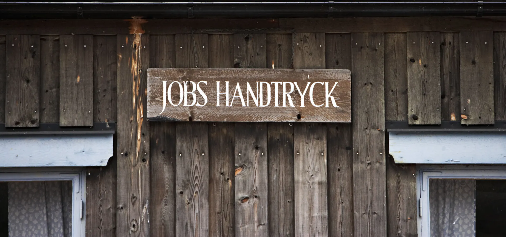 Skylt på husvägg med Jobshandstryck.
