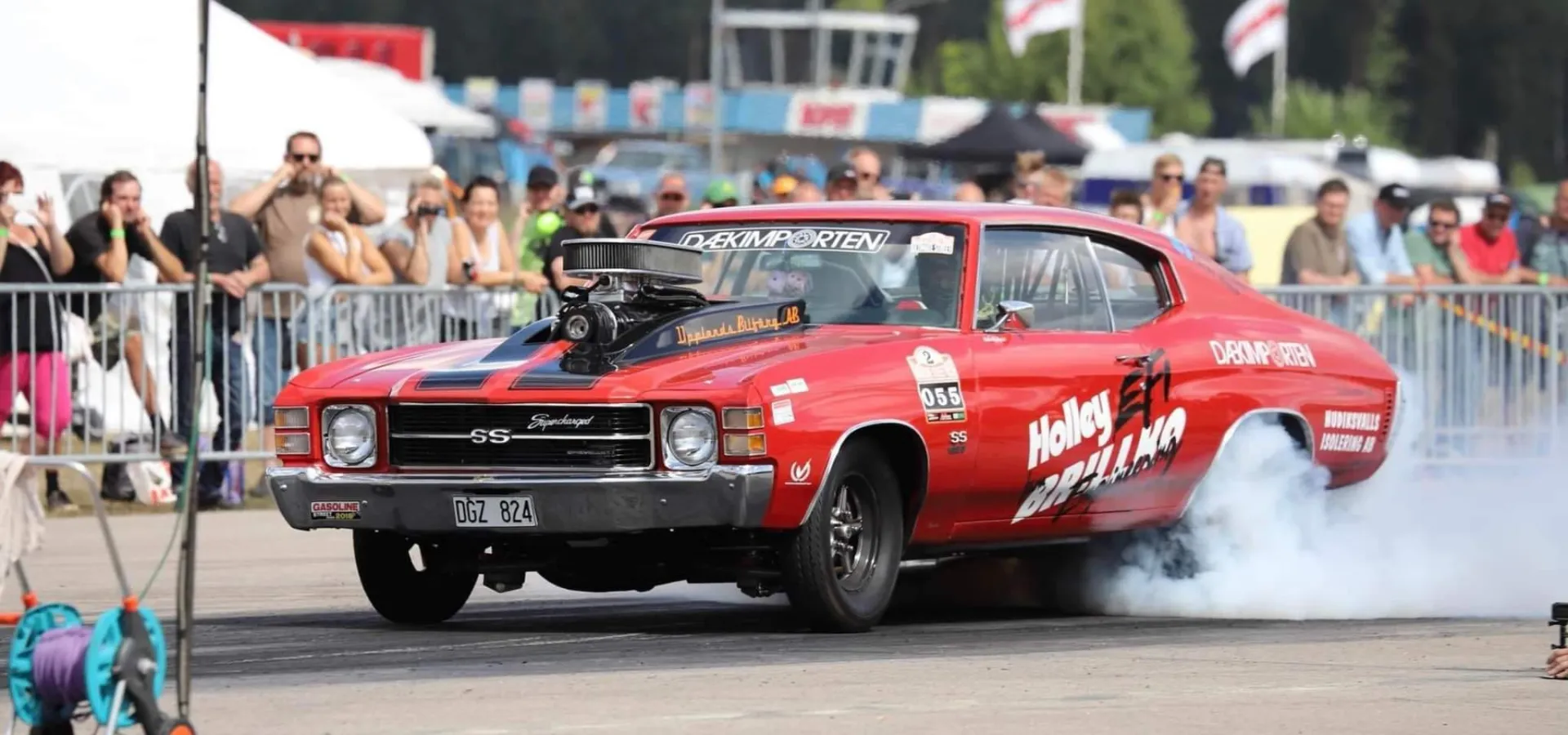 Röd bil på burnoutshow under Älvdalens Musik och Motorfestival.