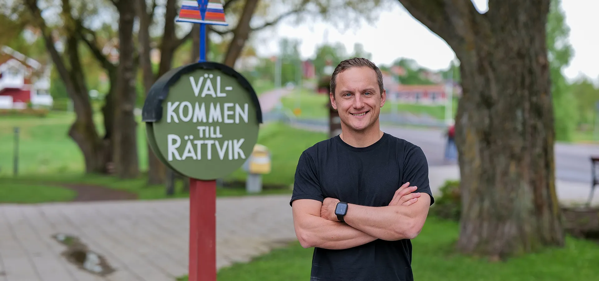Jojje Borssén i svart tröja, bredvid en skylt med texten Välkommen till Rättvik.