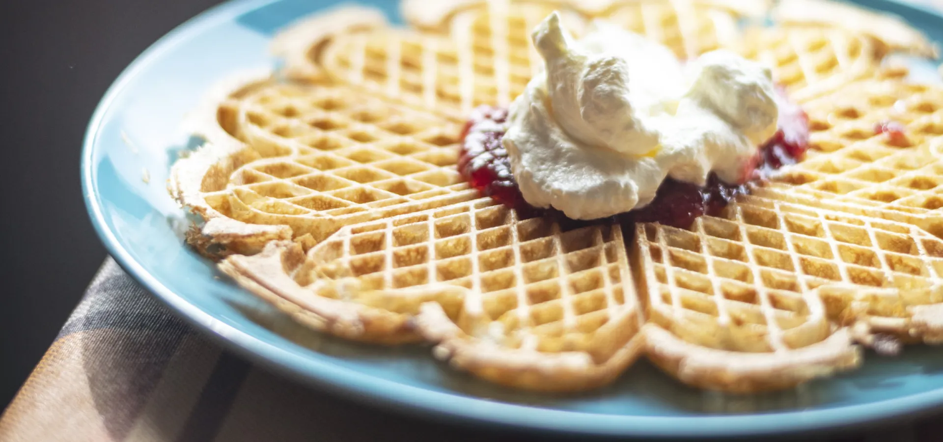 Våffla med grädde på en tallrik.