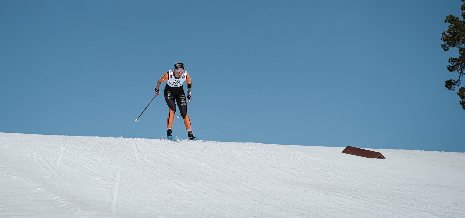Maja Dahlqvist åker längdskidor nedför en backe.