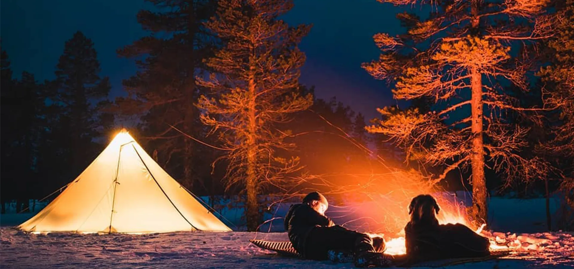 Tält och öppen eld på natten.
