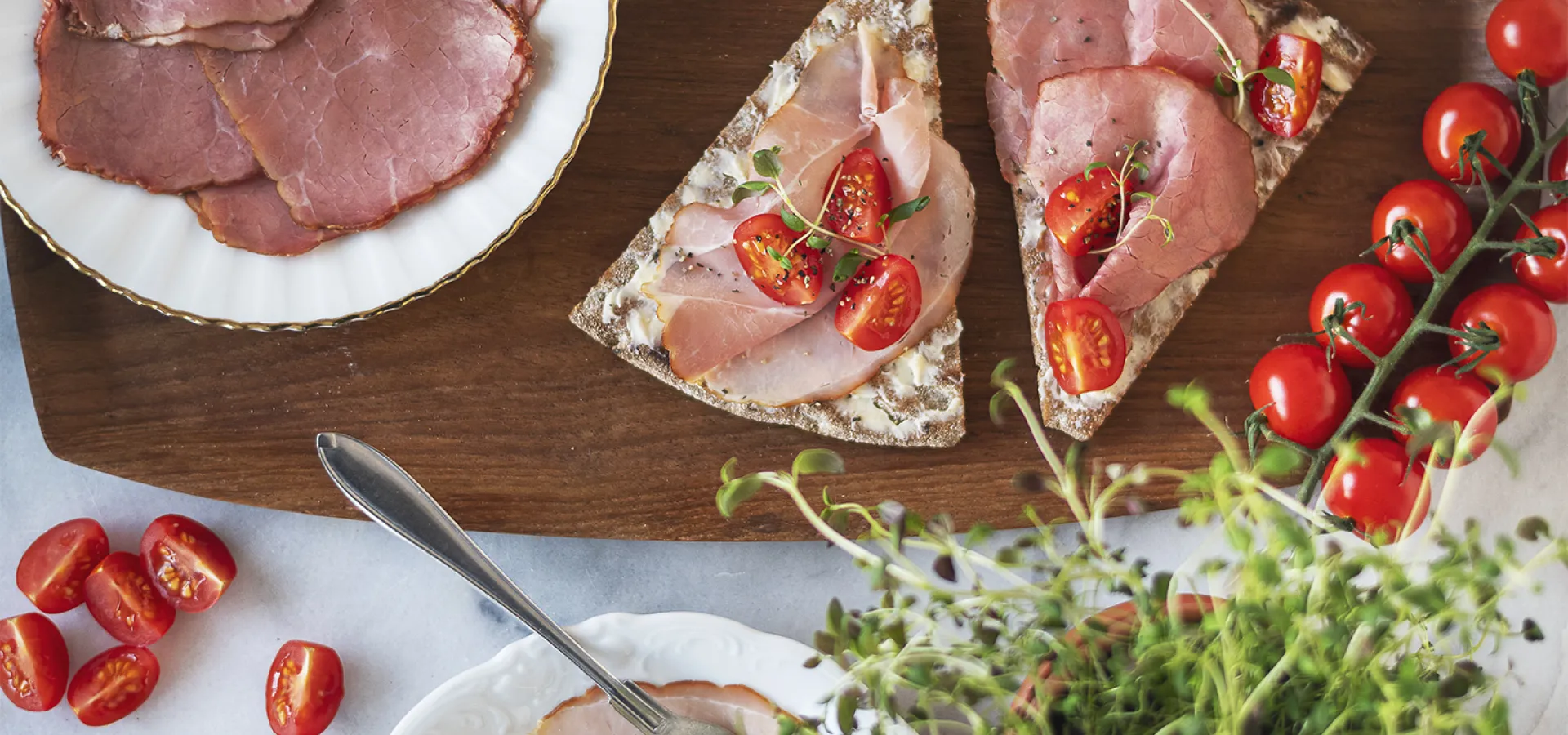 Vackert upplagt hårdbröd med skinka och tomater.