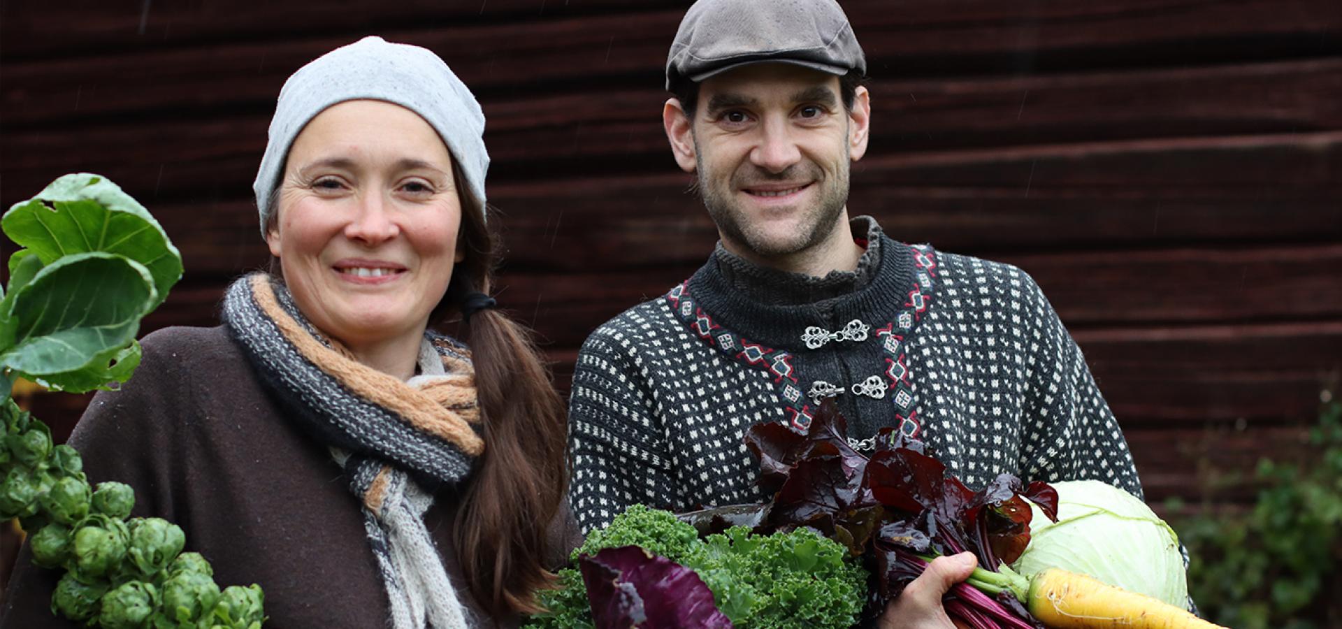 Nadina Hannäs Navier och Mikael Ganea håller i nyskördade grönsaker.