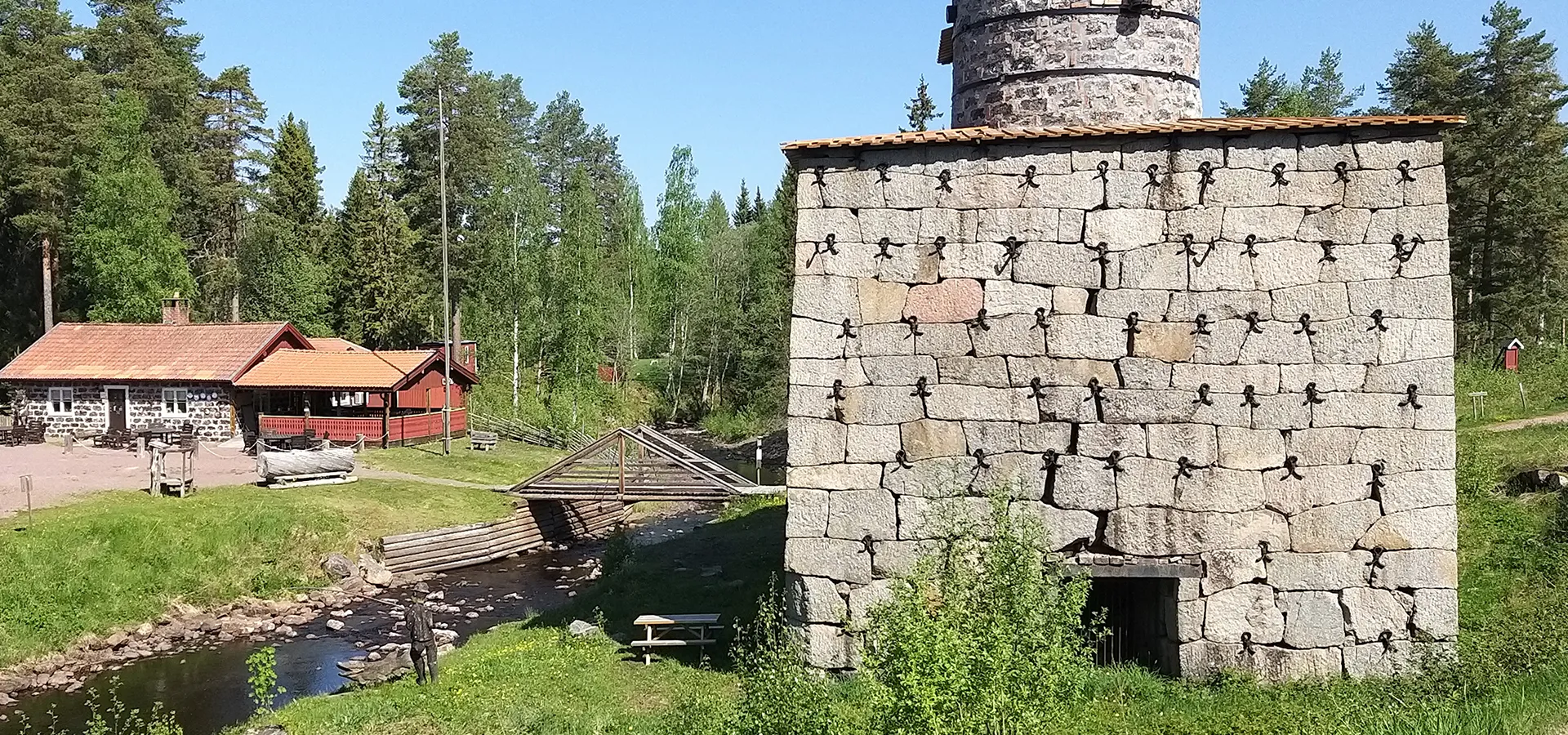 En äldre stenbyggnad syns vid ett vattendrag.