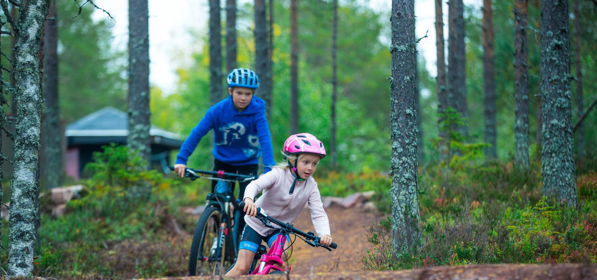 Två barn som cyklar på flowtrail-leden i Orsa Grönklitt.