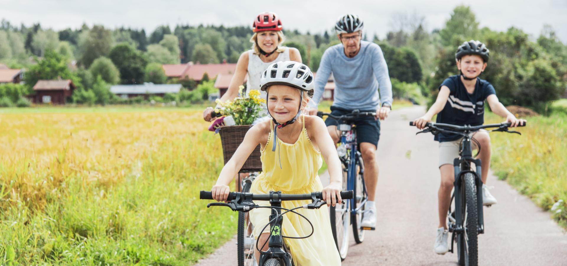 Två vuxna och två barn cyklar i Tällberg i Dalarna.