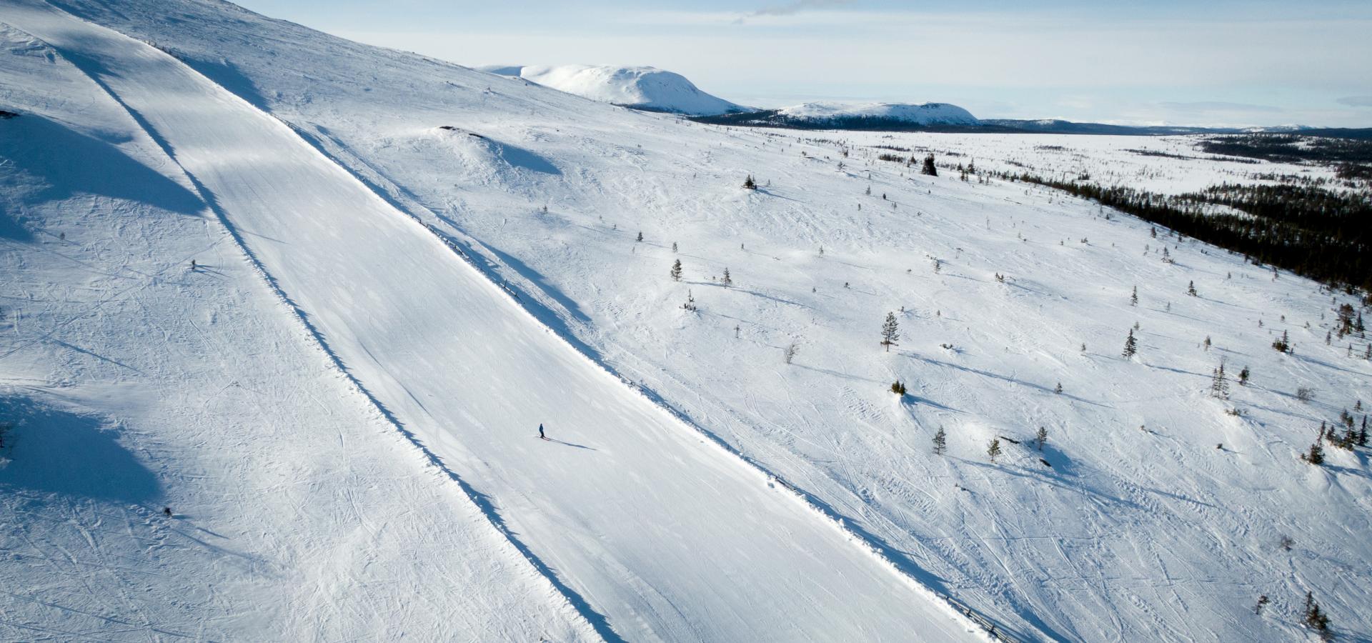 Ensam alpin skidåkare på väg nedför backe i Fjätervålen.