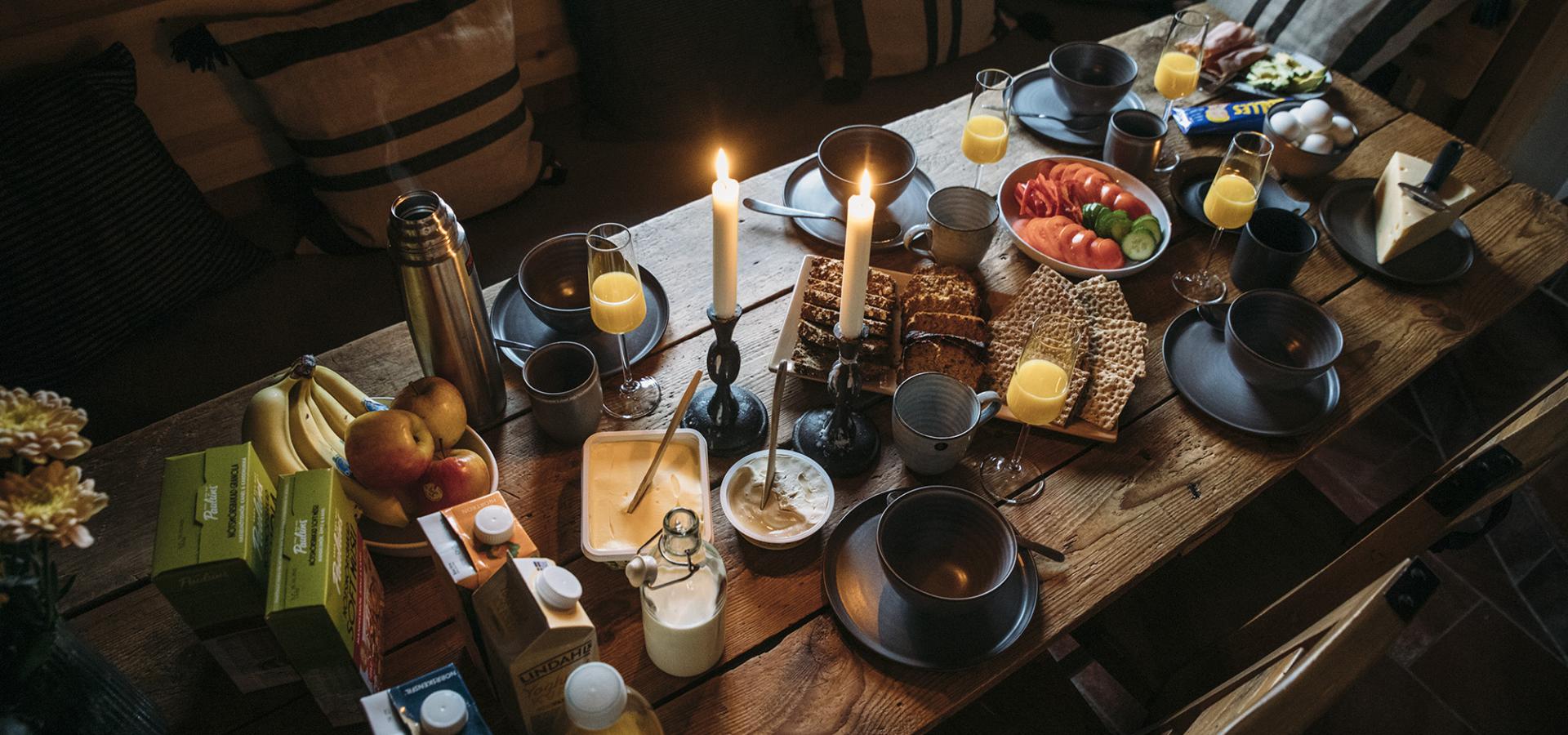 Ett mysigt bord med mat och tända ljus.