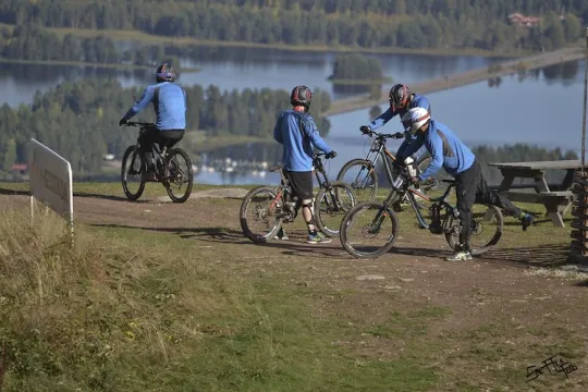 Four downhill cyclists in the starting pits to make their way down the hill.
