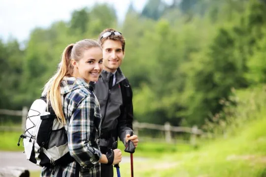 Young couple with backpacker and poles