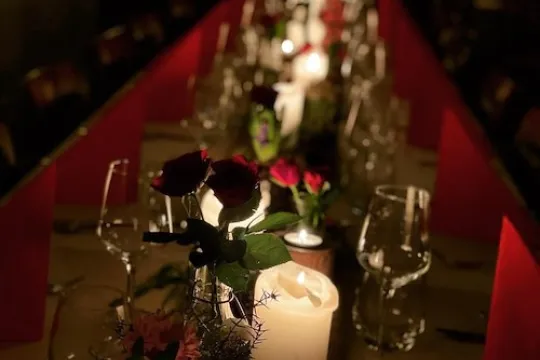 Set table with red cloth and candles. 