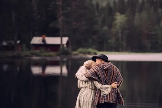 Ett par står och kramar varandra på en brygga.