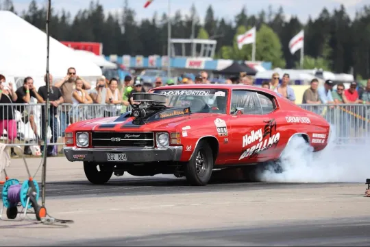 Röd bil på burnoutshow under Älvdalens Musik och Motorfestival.