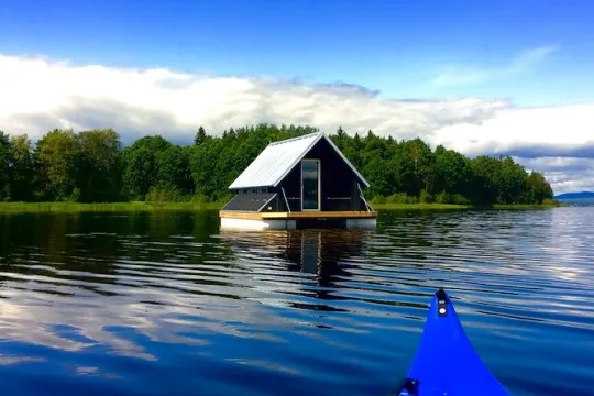 Stuga på en flotte i vattnet. 